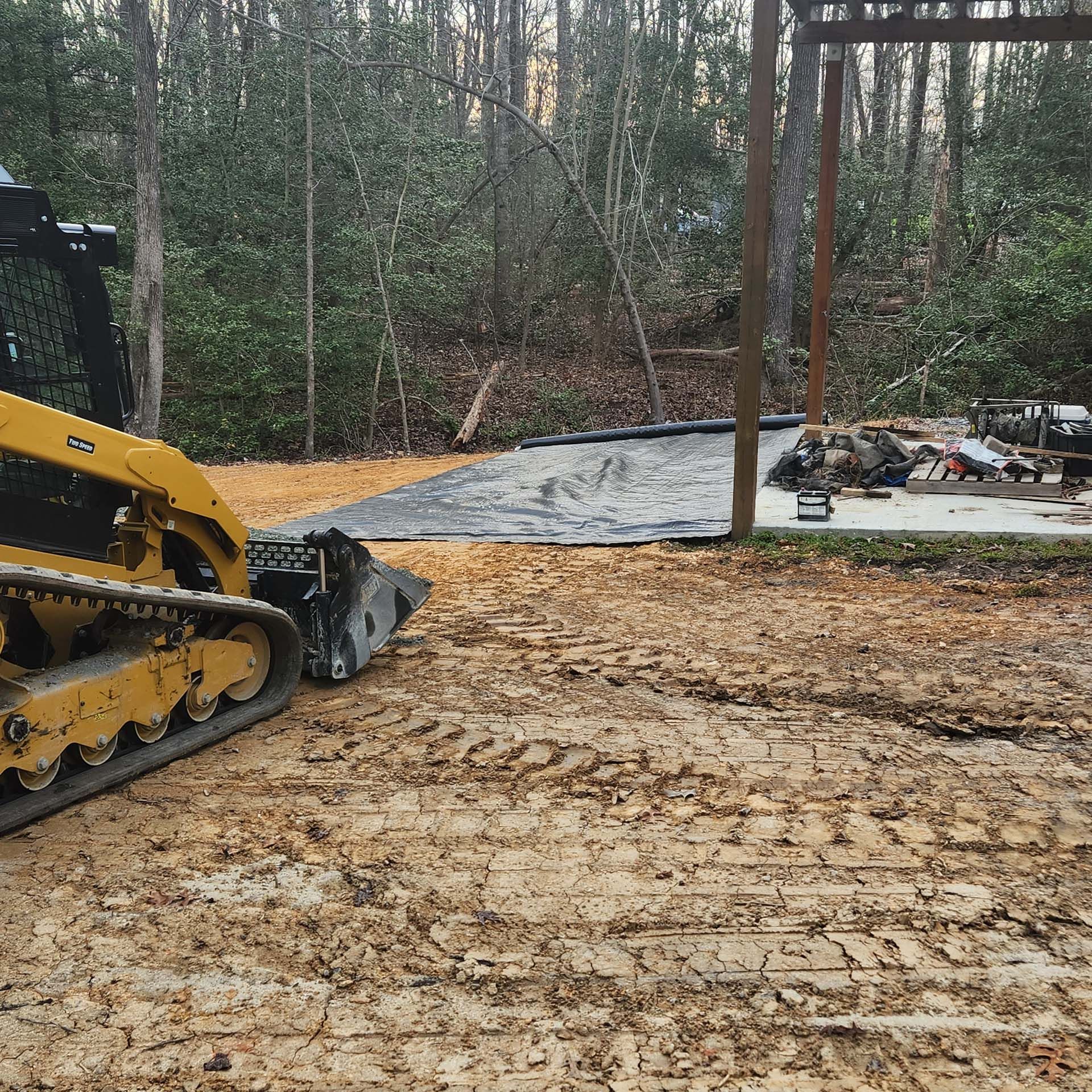 A yellow bulldozer is sitting on top of a dirt field.