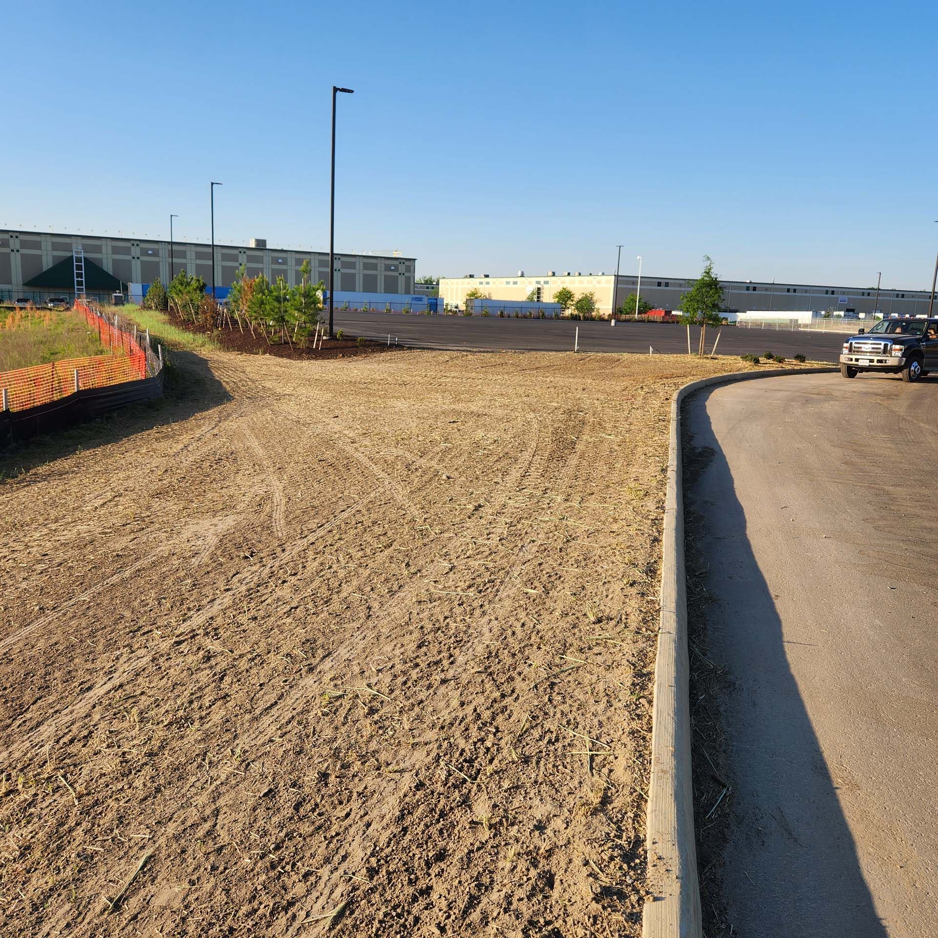 A car is parked on the side of a dirt road