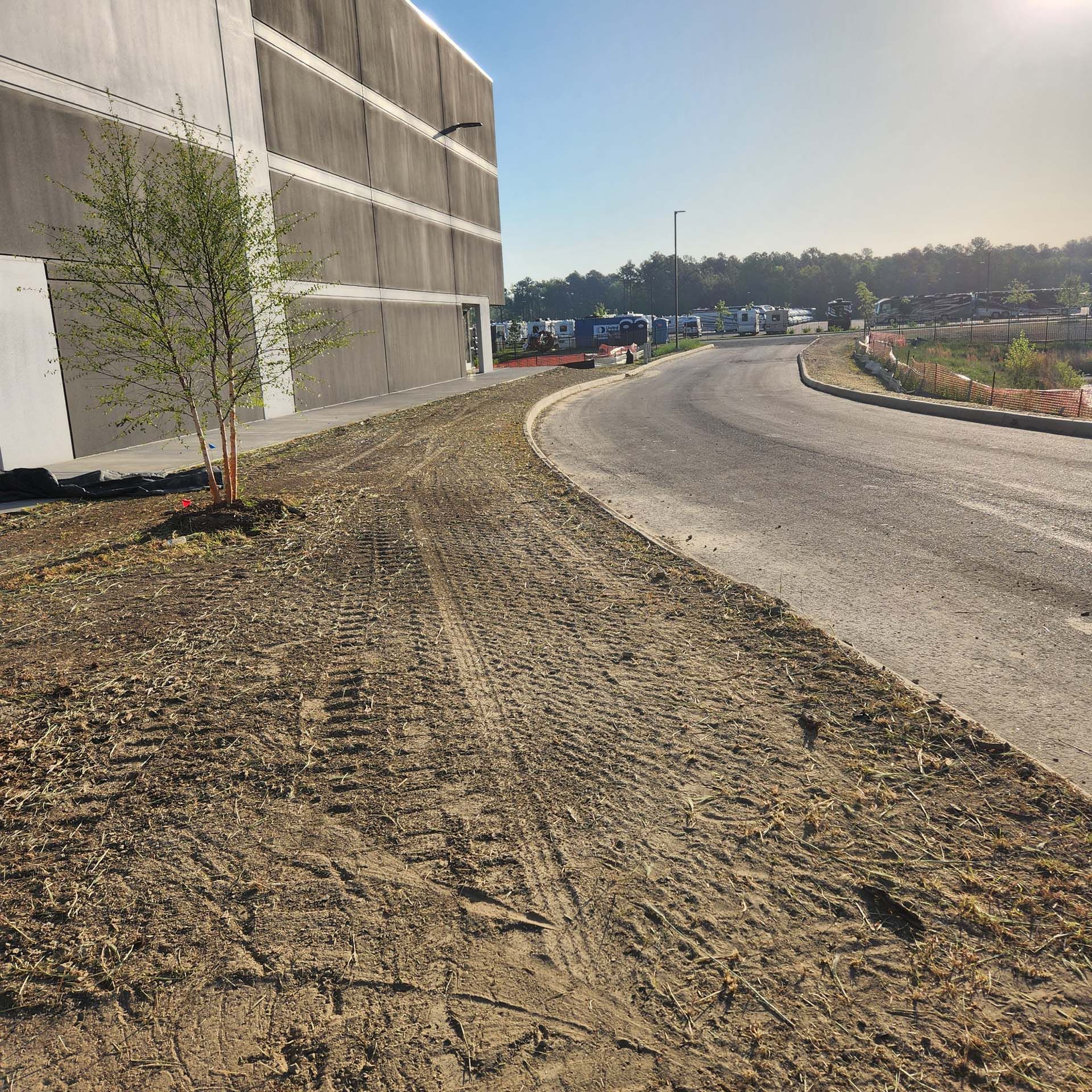 A dirt road with a building in the background