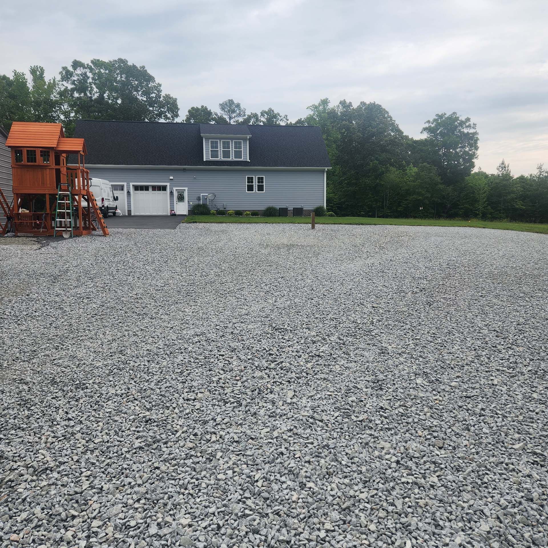 A large pile of gravel is in front of a house.