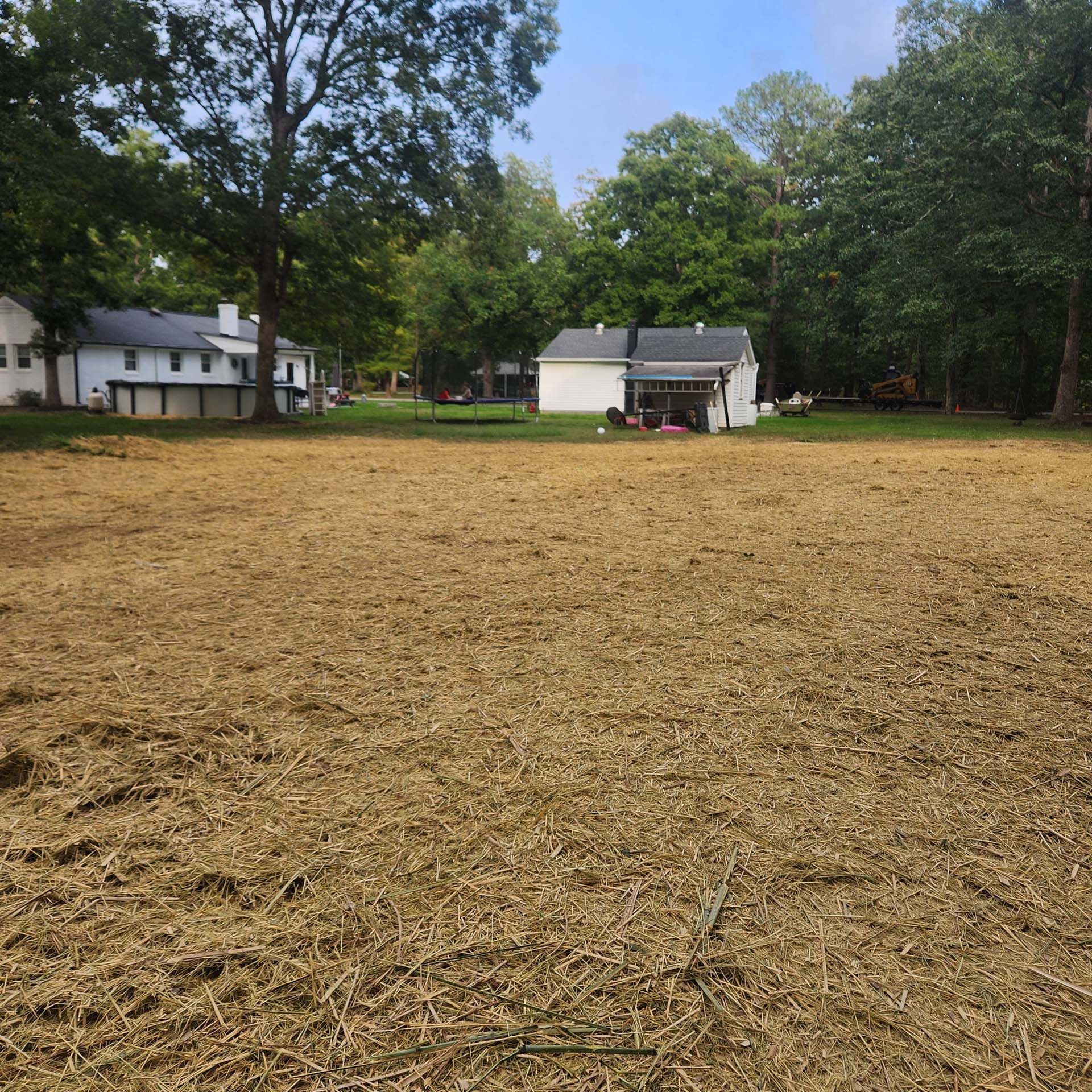 A large grassy field with a house in the background