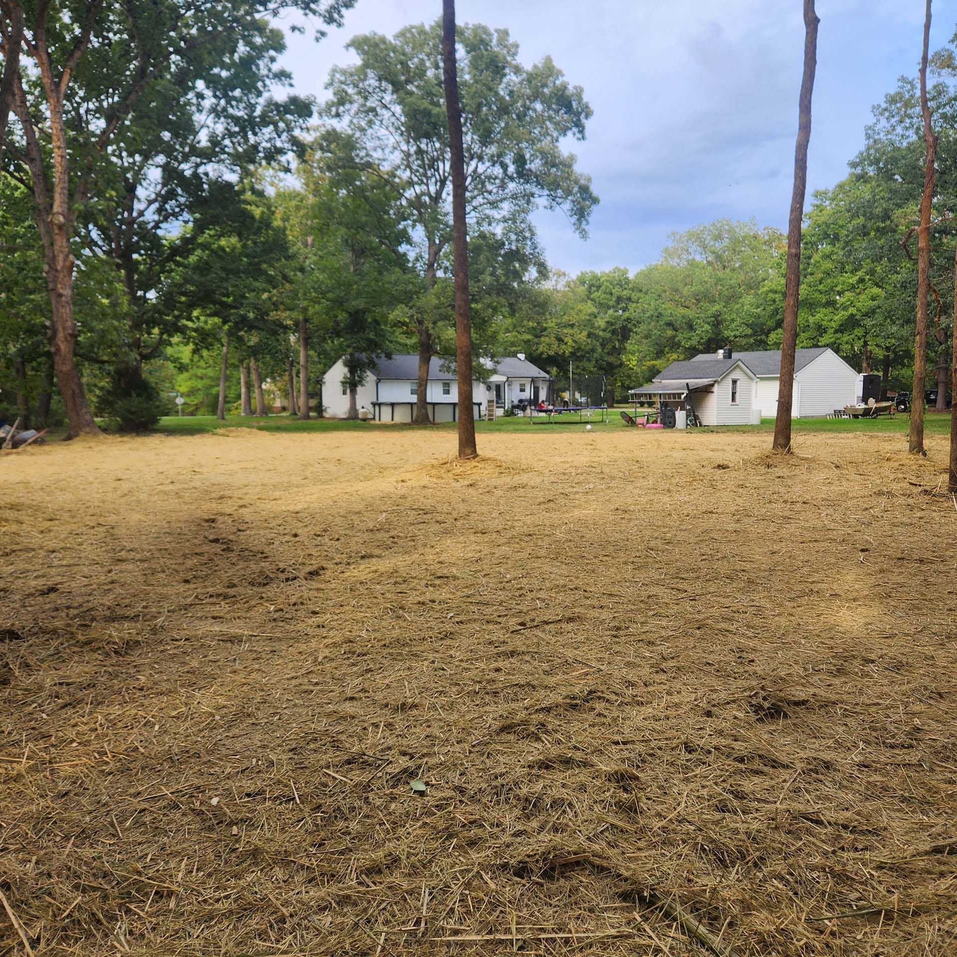 A dirt field with a house in the background