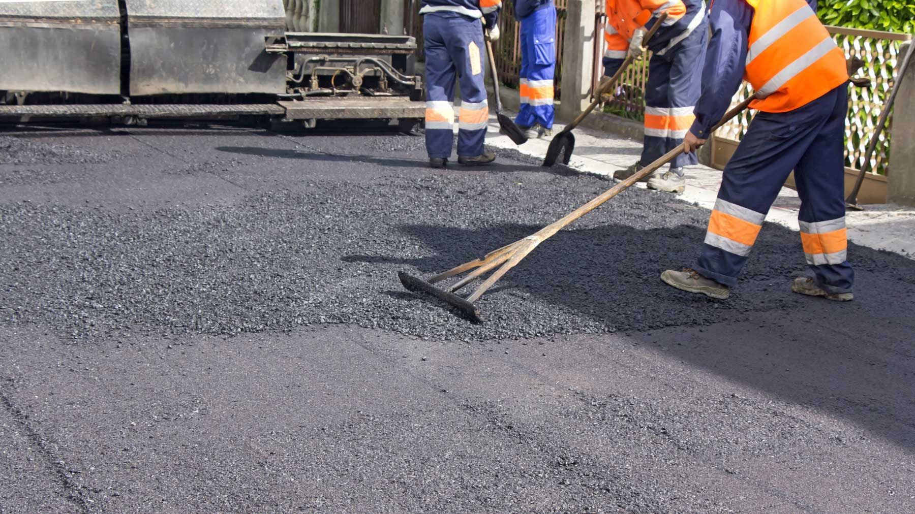 Construction Worker Pouring Cement Using a Concrete Pump Hose
