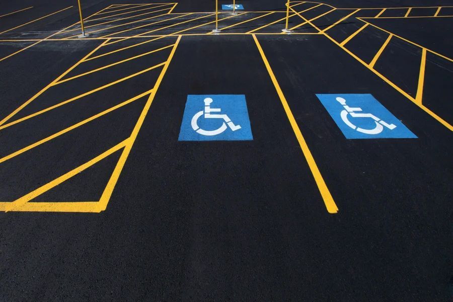 Two handicapped parking spaces are painted in a parking lot.