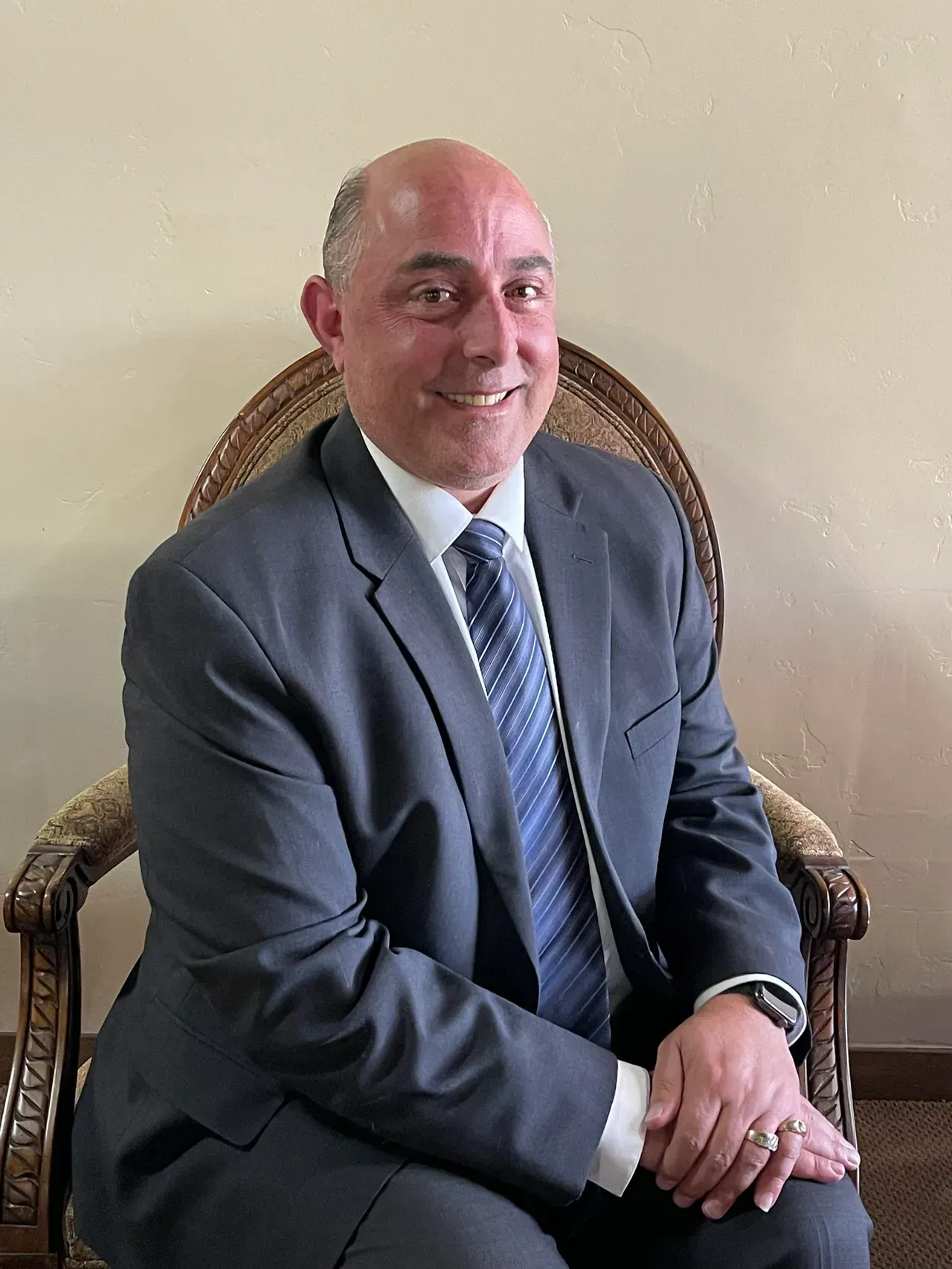 a man in a suit and tie sits in a chair