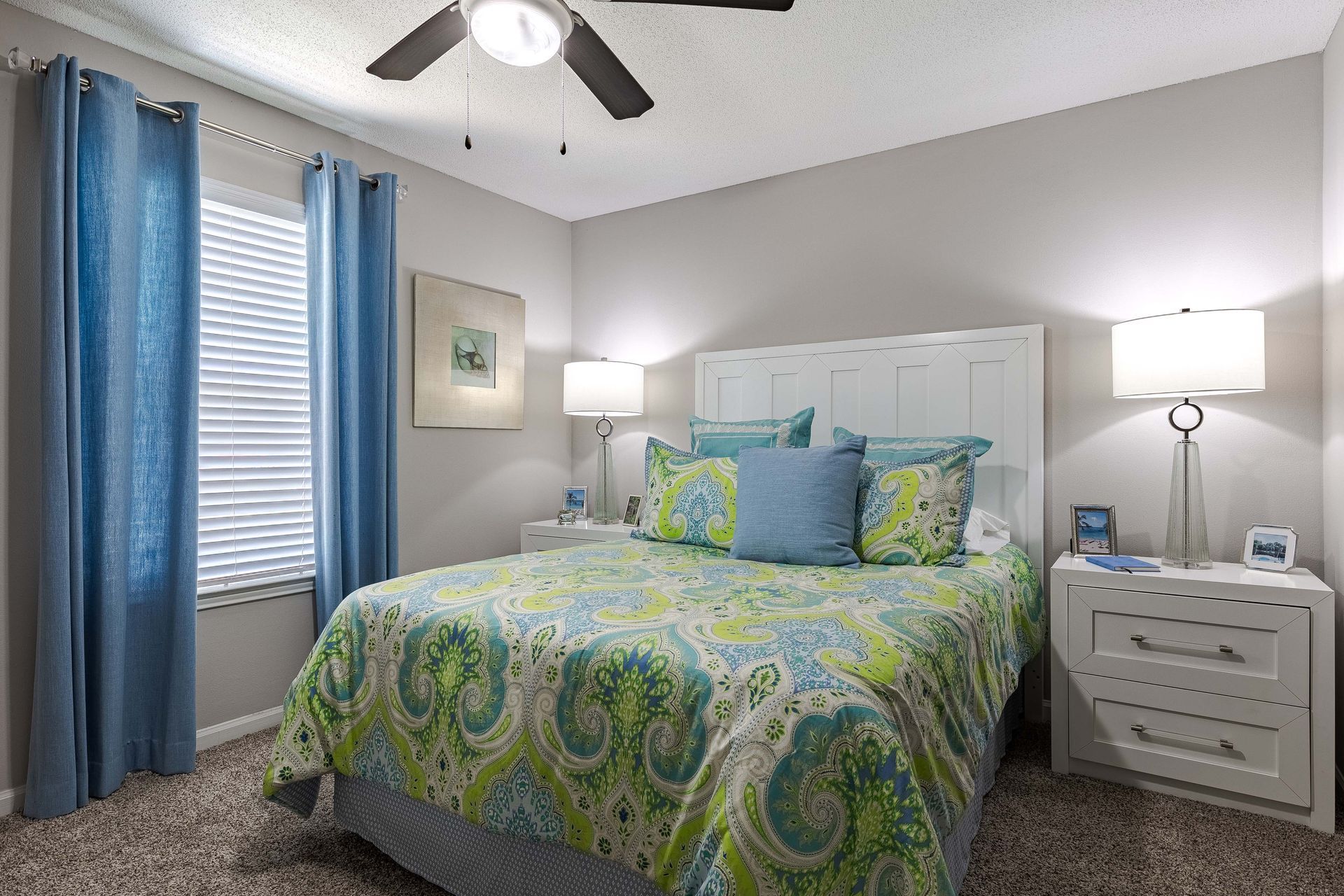 Bedroom with a bed, nightstands, window, and blue and green accents.
