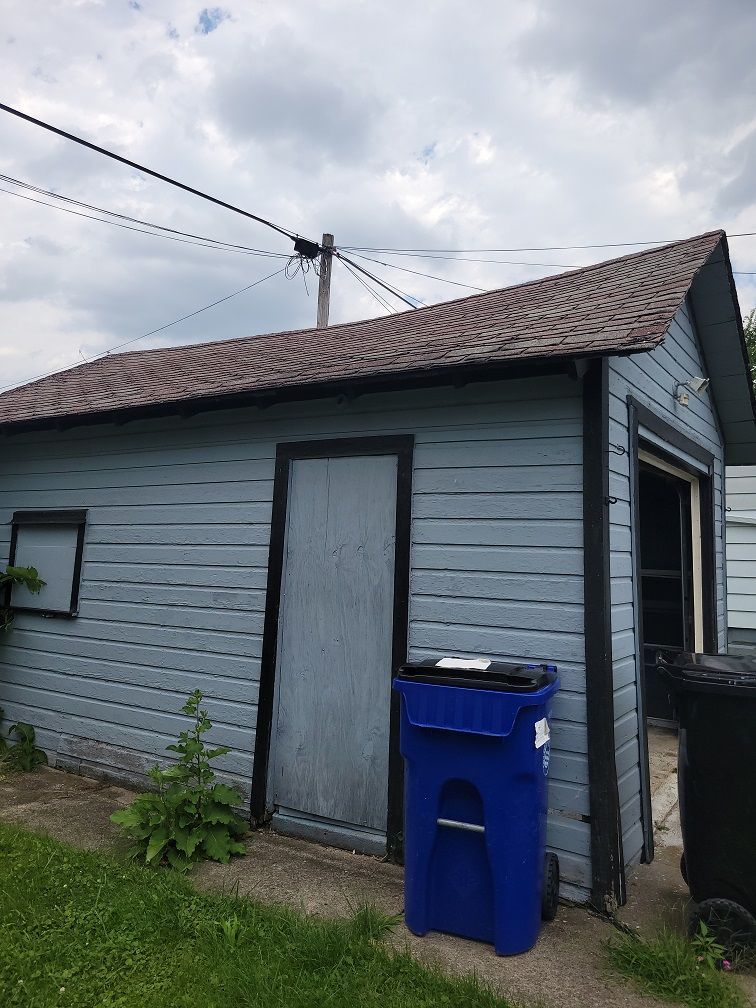 Blue Trashbin Outside The House — Cleveland, OH — Ohio Roofing Siding & Slate LLC