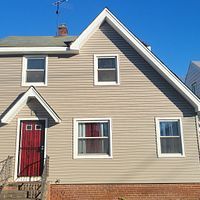 The front of a house with a red door and windows.