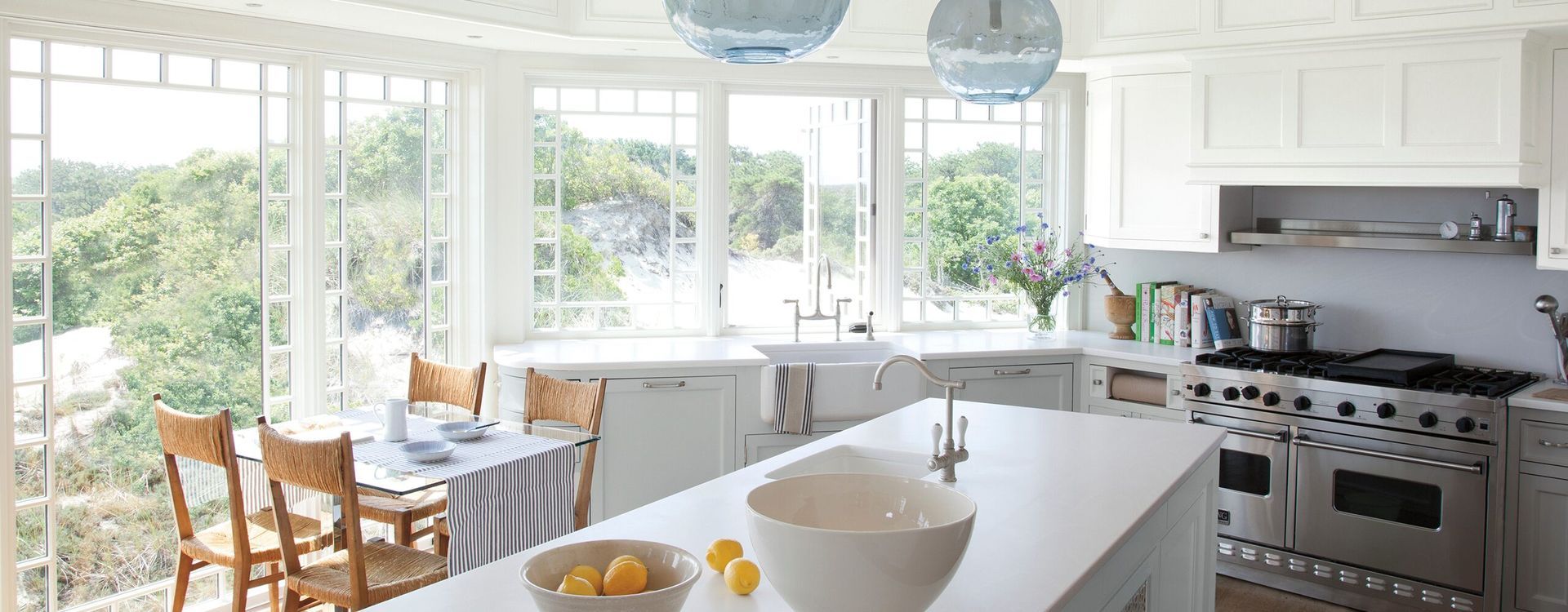 Bright white kitchen with large windows  and white cabinets