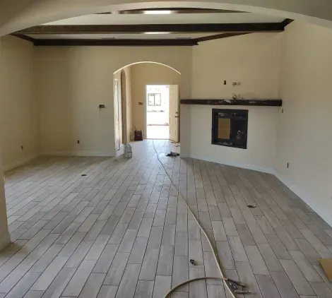 An empty room with a wooden floor and a fireplace