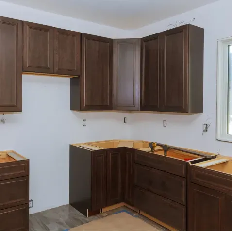 A kitchen under construction with wooden cabinets and drawers