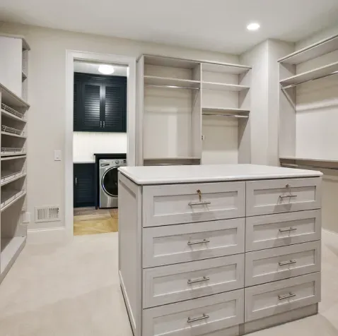 A walk in closet with a large island in the middle