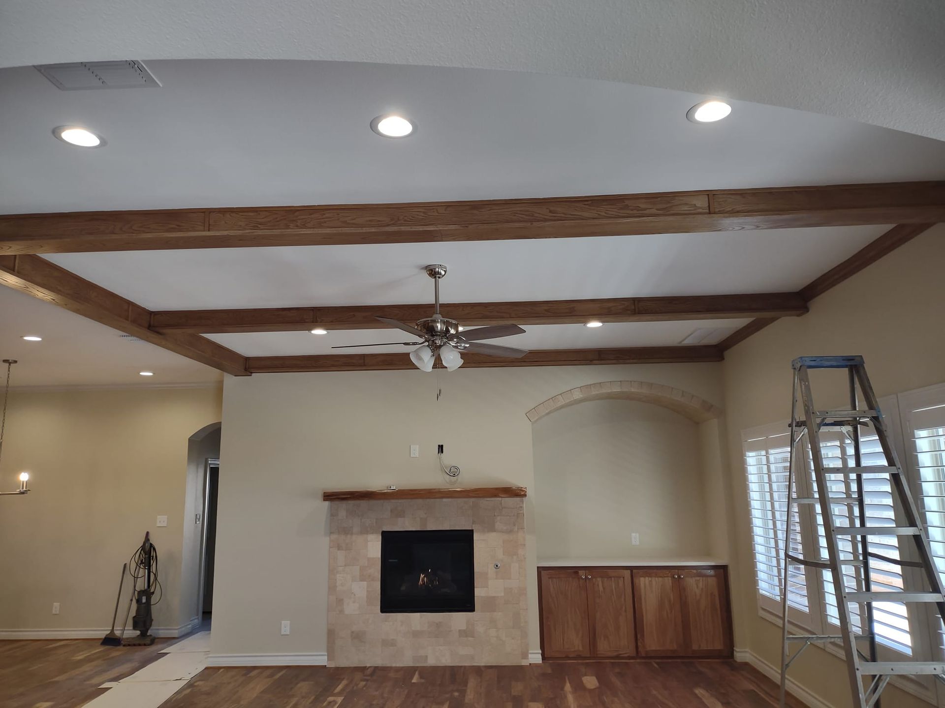 A living room with a fireplace and a ceiling fan