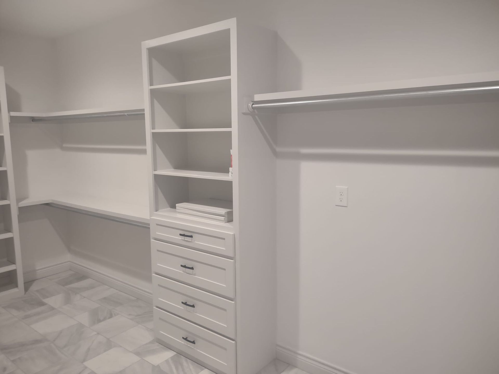 A walk in closet with lots of shelves and drawers.