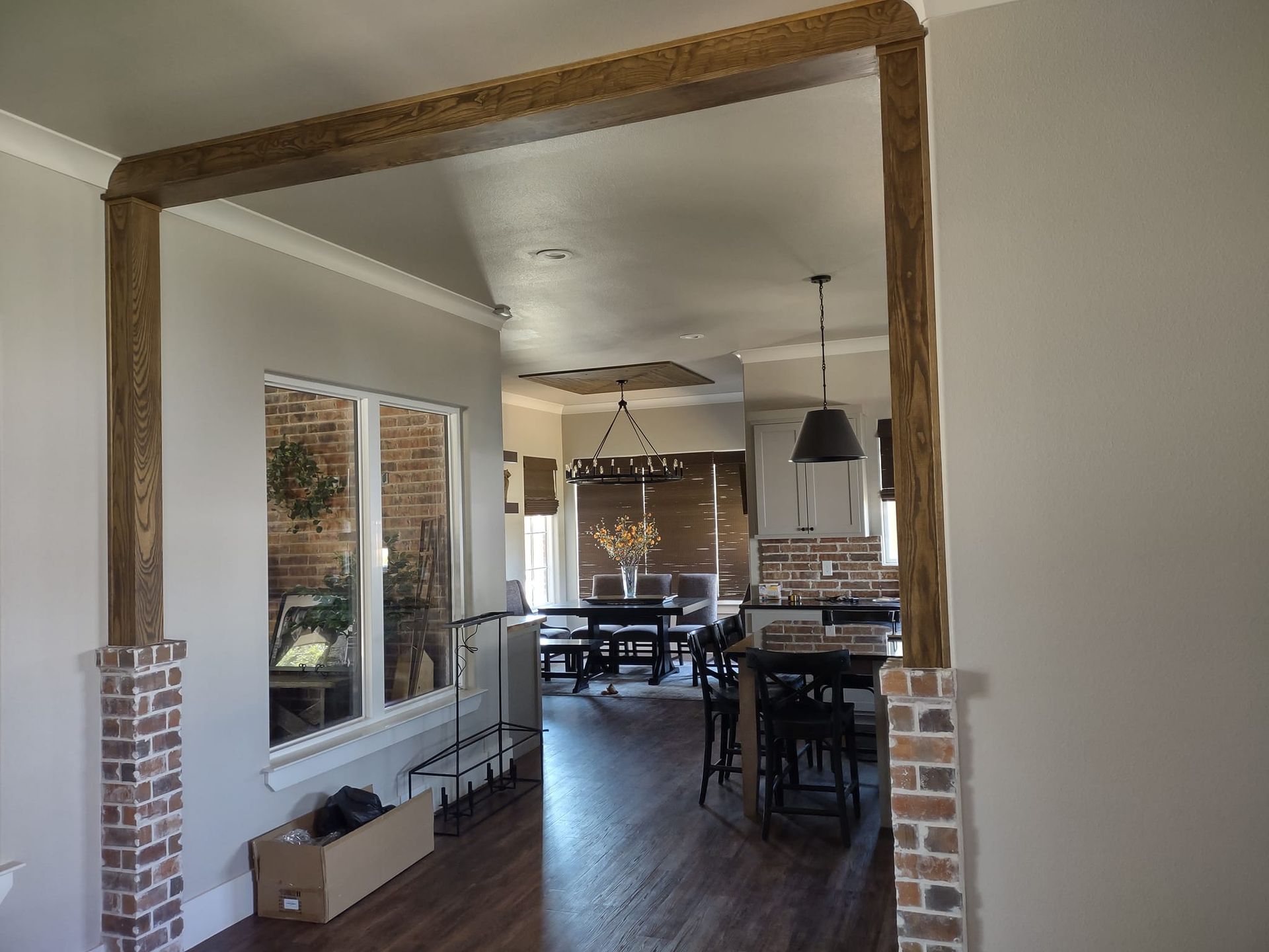 A living room and dining room in a house with wooden beams.