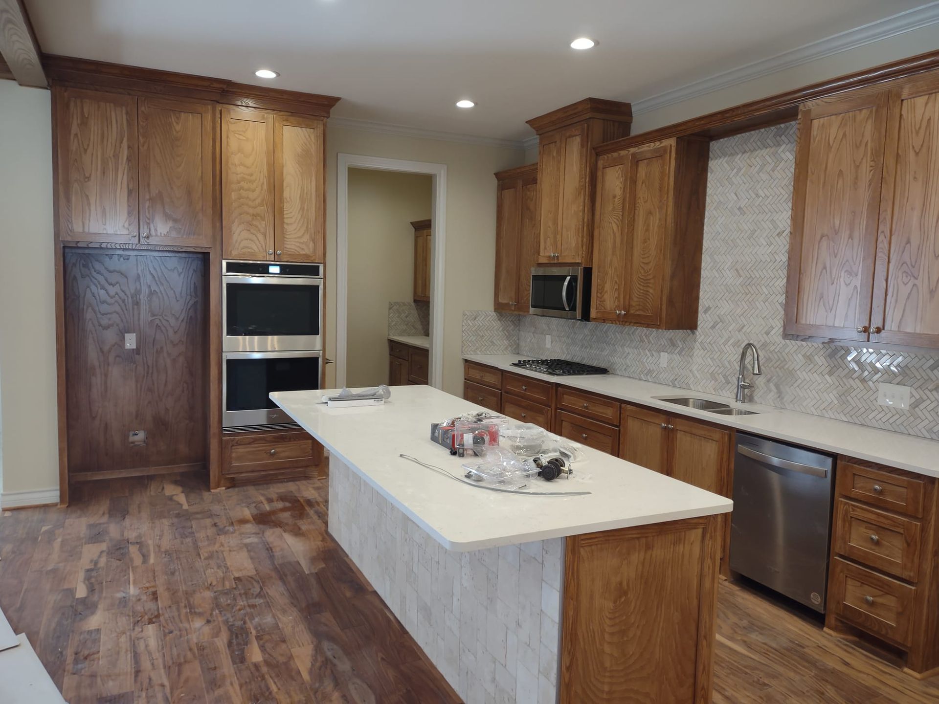 A kitchen with wooden cabinets , stainless steel appliances , and a large island.