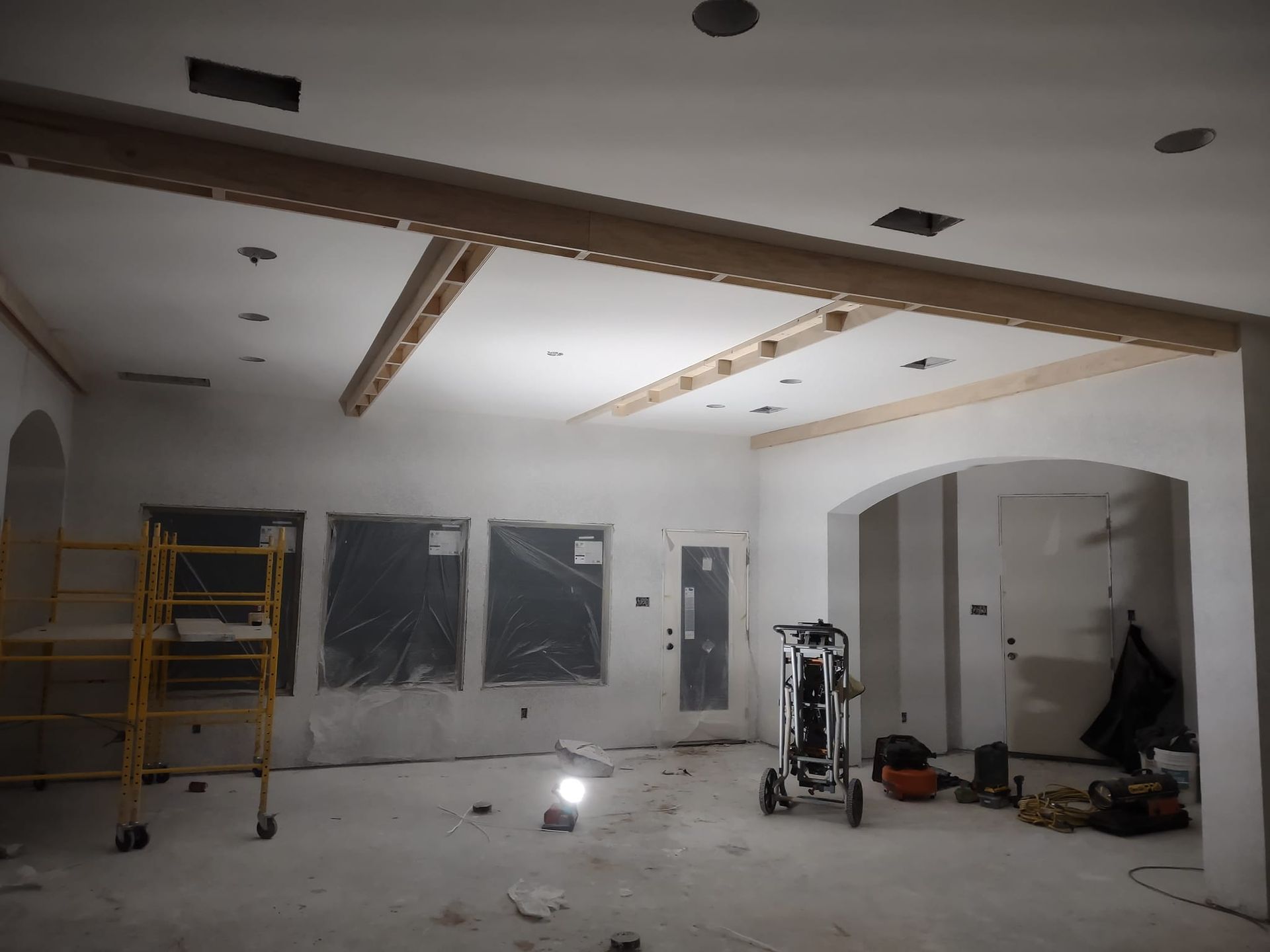 An empty room with a scaffolding and a light on the floor