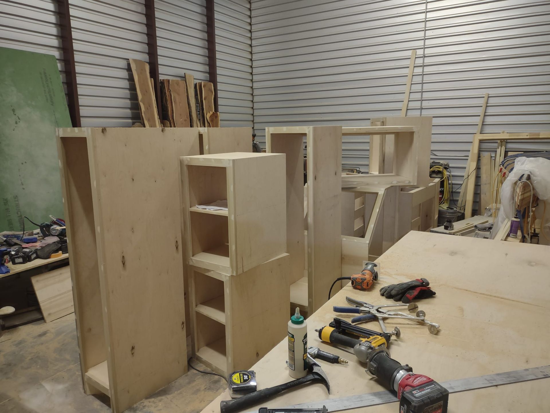 A woodworking shop with a lot of wood and tools on the table