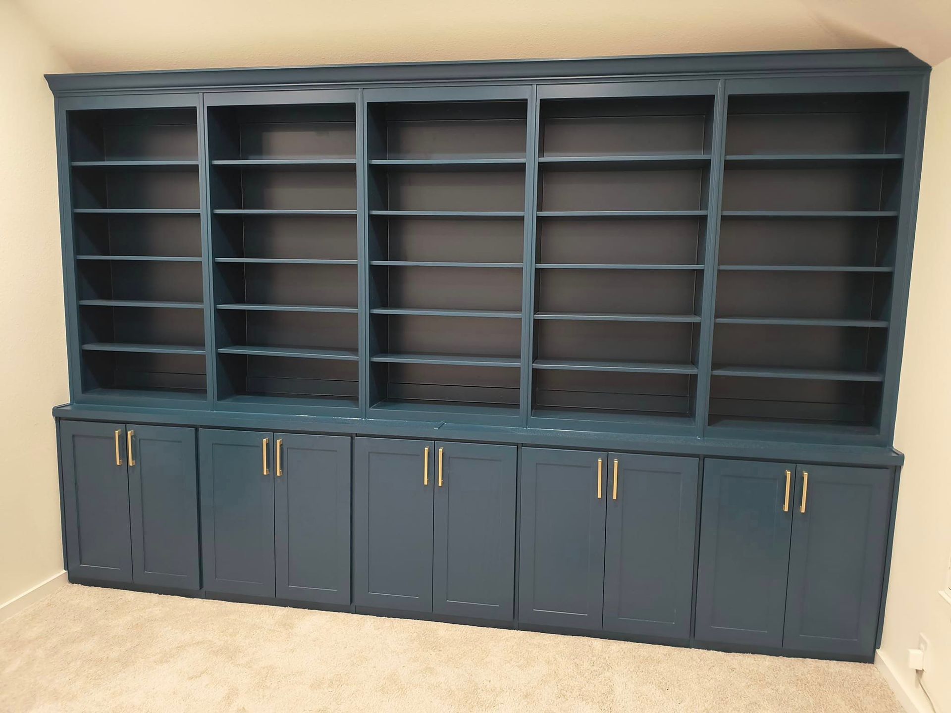 A large bookcase with lots of shelves and cabinets
