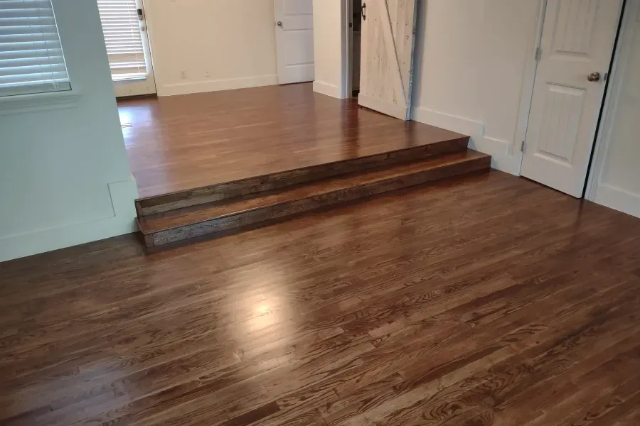 A room with hardwood floors and stairs in it.