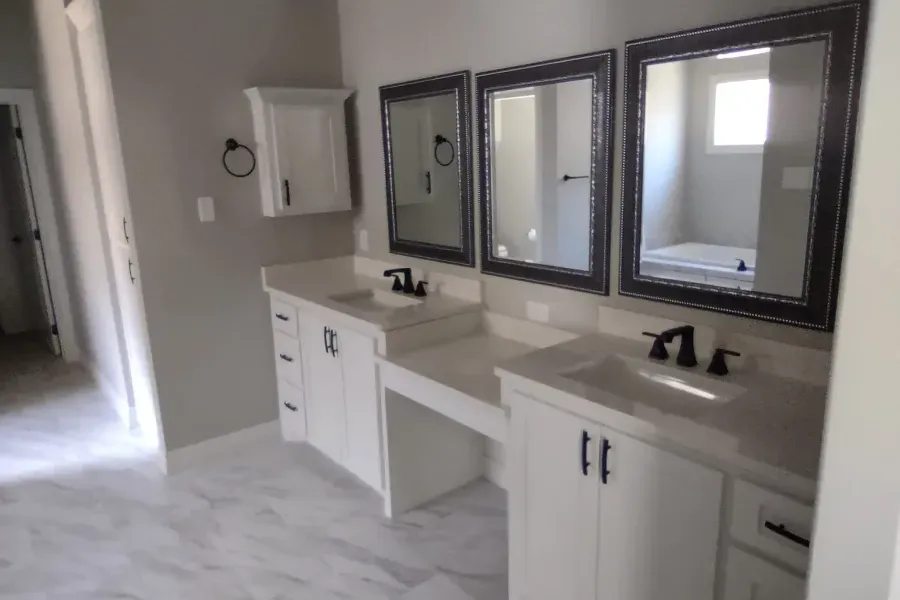 A bathroom with two sinks and three mirrors
