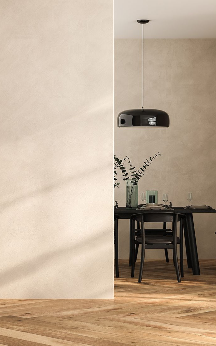 Wooden floor and wall with a black dining table, chair, and pendant light.
