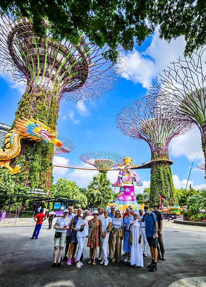 Travel to Southeast Asia - A group of people posing for a picture in front of a statue in Singapore