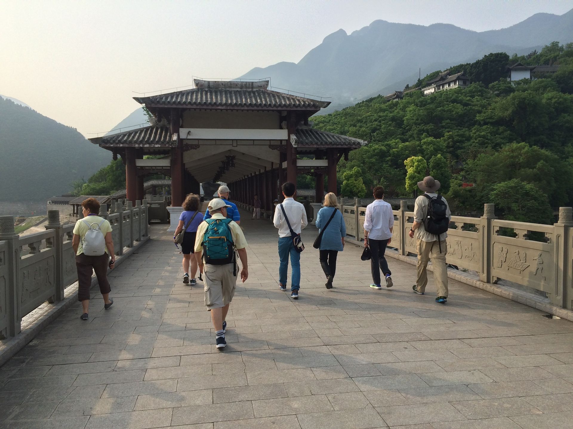 Group Travel Vacations in China - A group of people walking along the Great Wall of China with mountains in the background