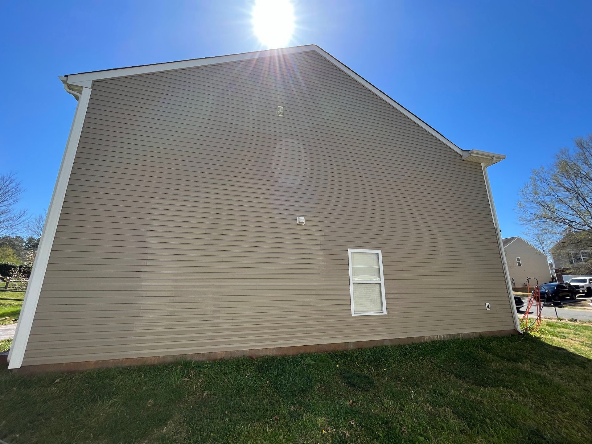 The sun is shining on the side of a house.