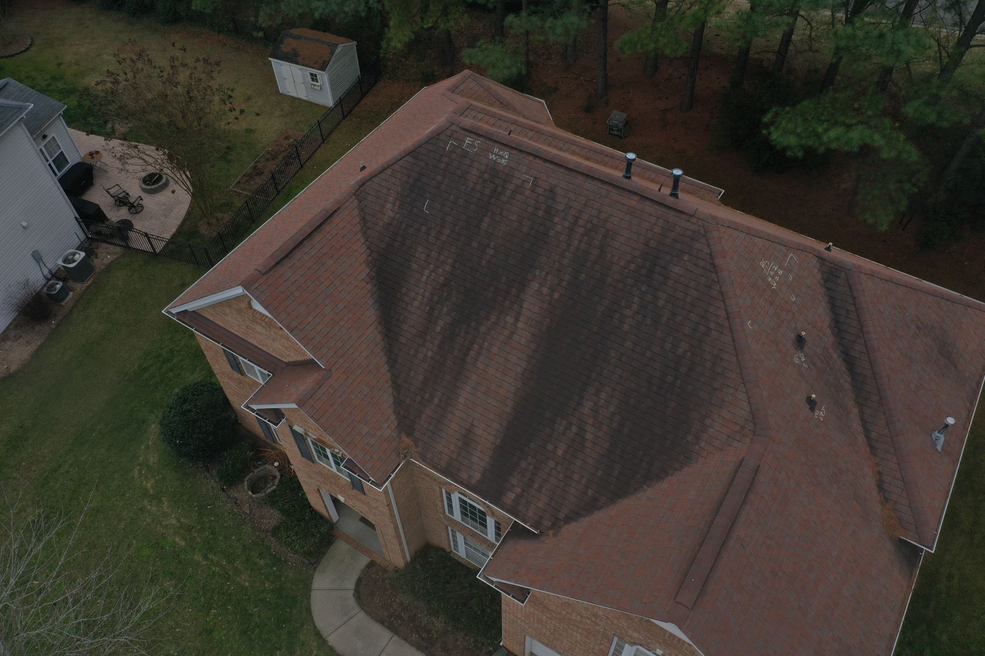 A white house with a brown stain on the side of it.