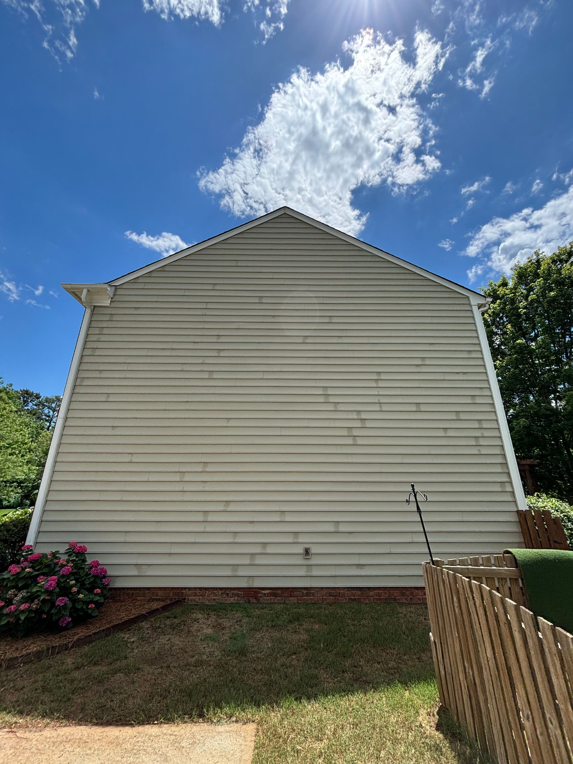 The side of a house with a window and an air conditioner.