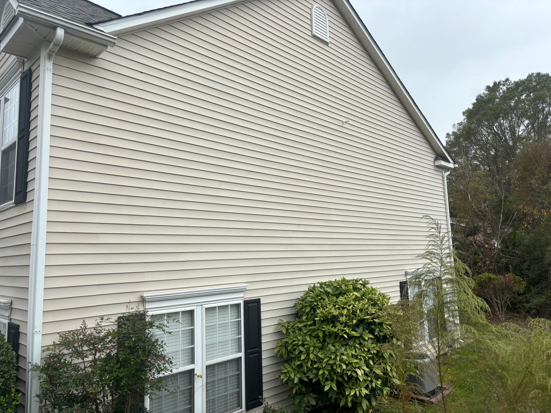 The side of a house with a window and an air conditioner.