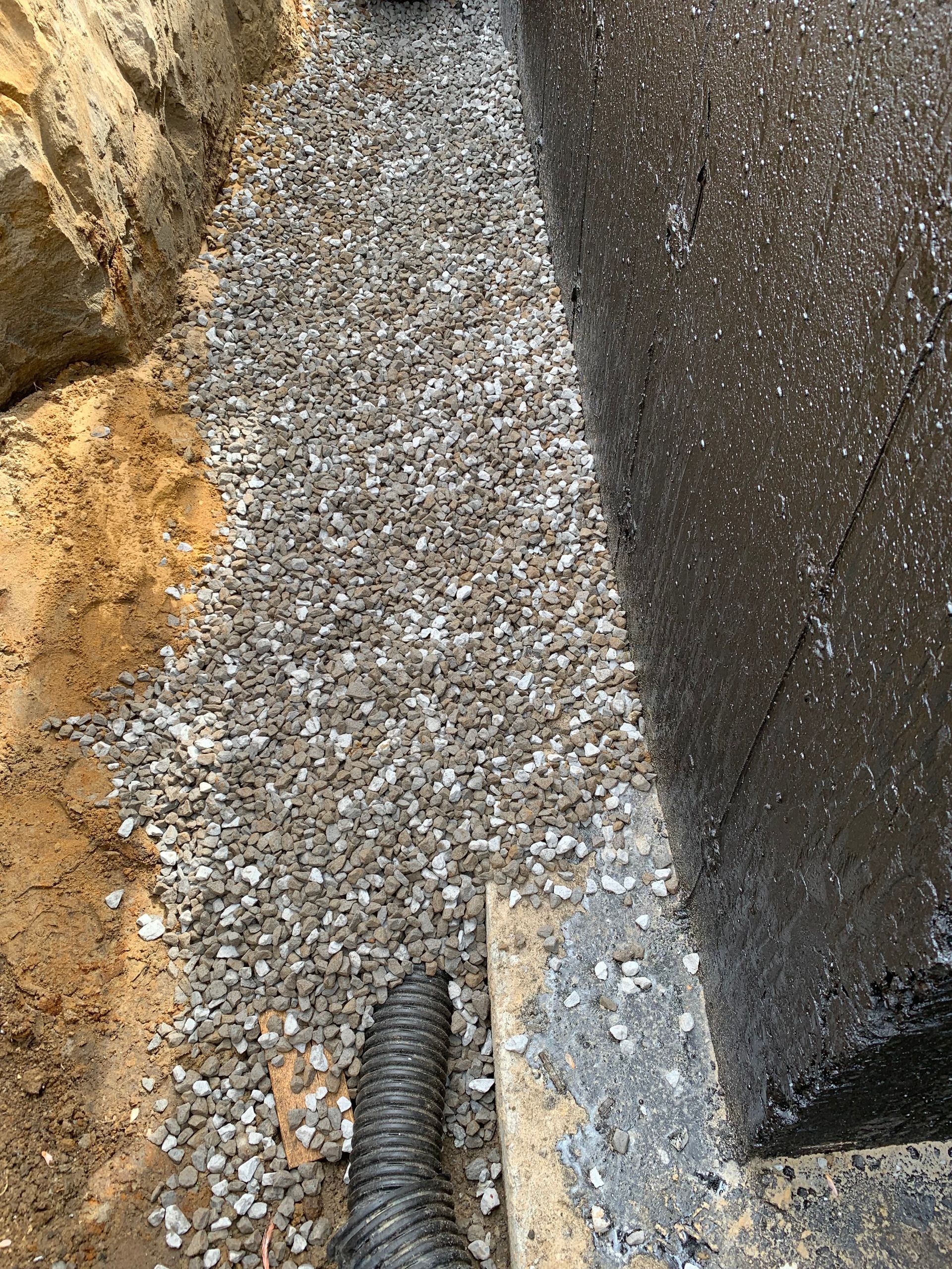 Un gros plan d'un tas de gravier à côté d'un mur.