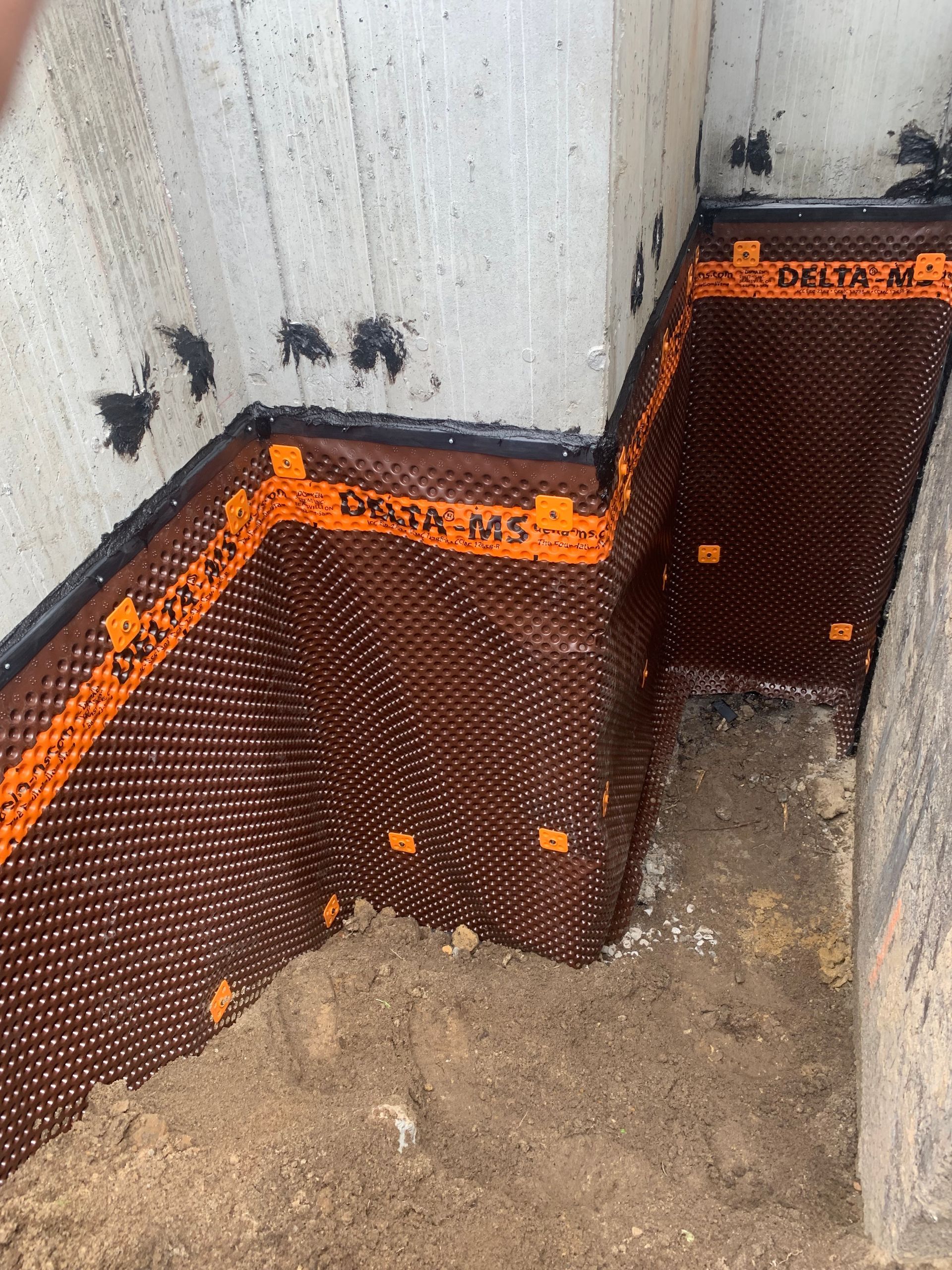 Un coin d'un sous-sol avec un système de drainage installé.