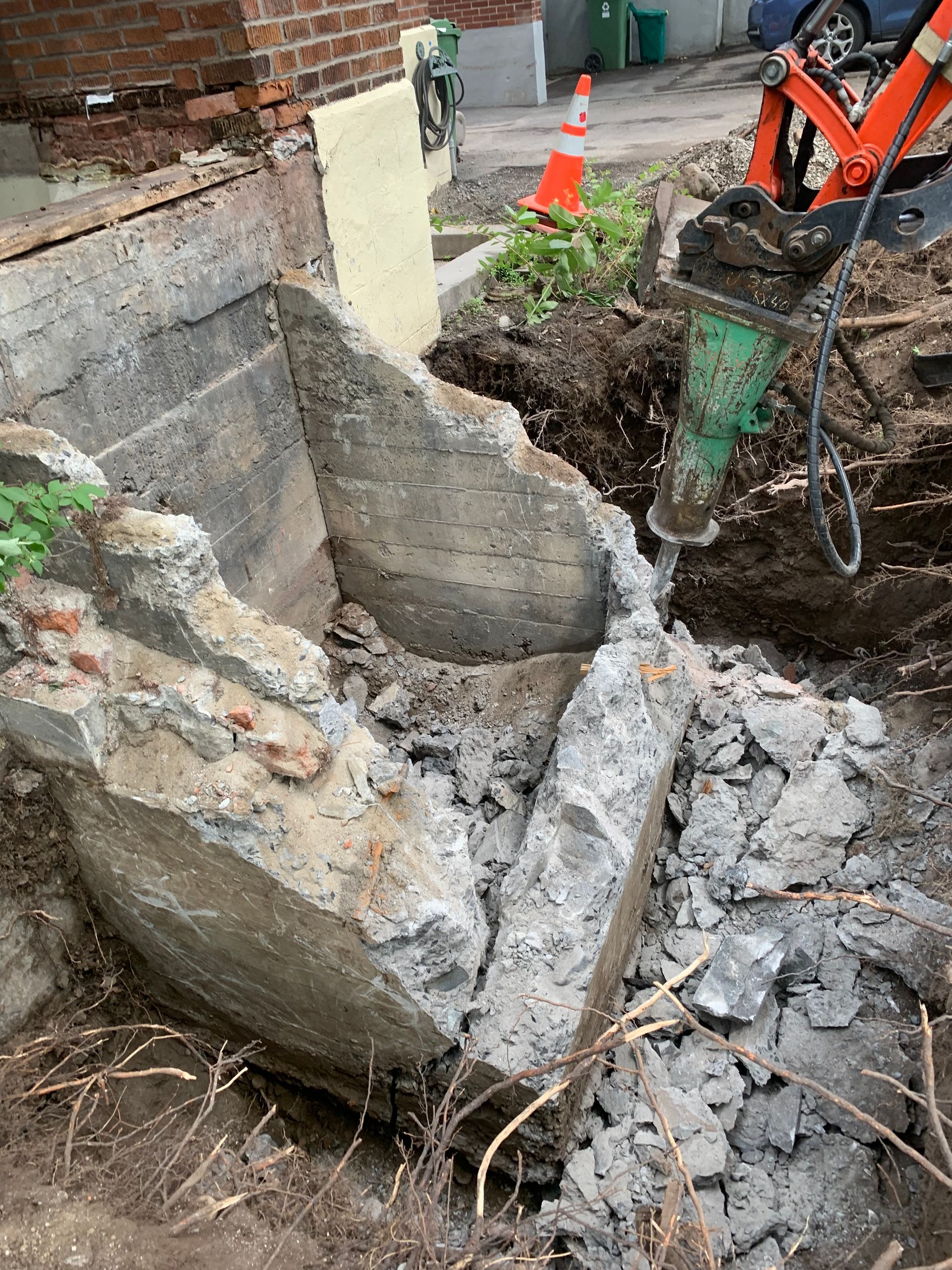 Un gros rocher est retiré du sol par une machine.