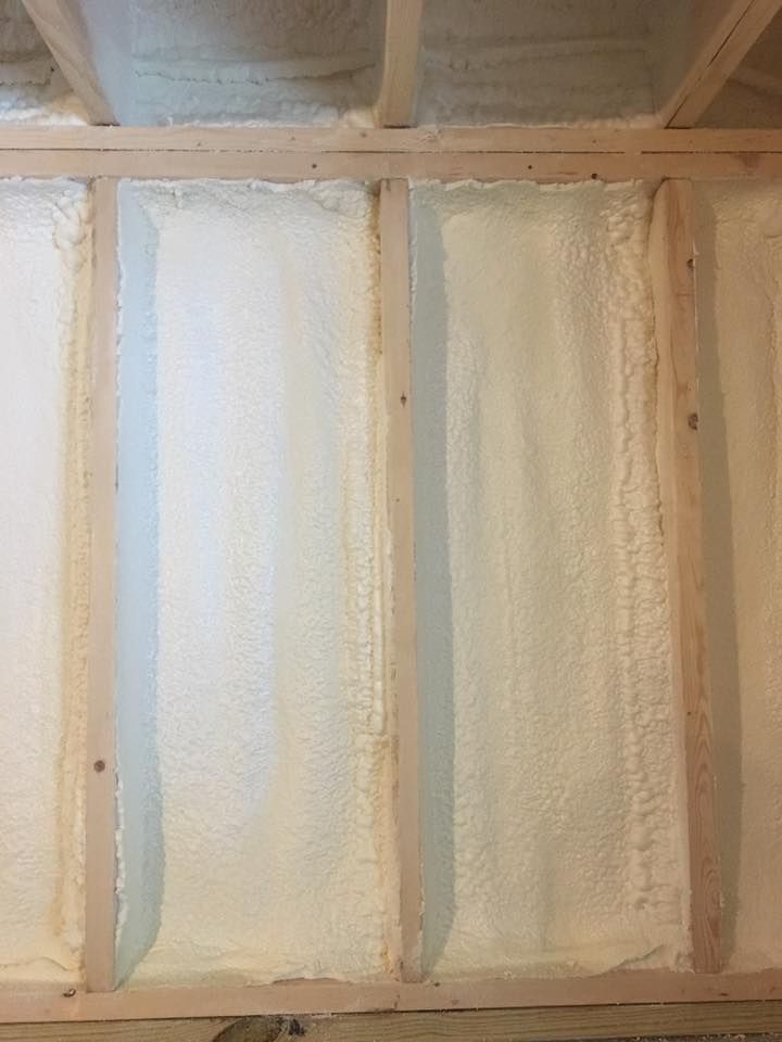 Close-up of a textured white and beige wall with vertical panels and a curved ledge at the top left