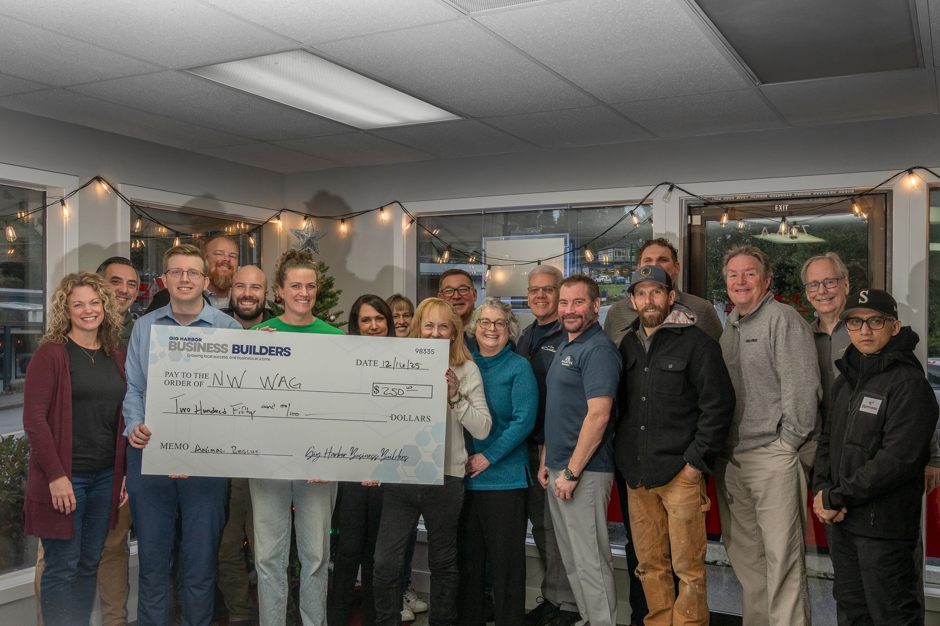 The Gig Harbor Chamber Pillars Group holding a check with a $250 donation to  NW Wag. 