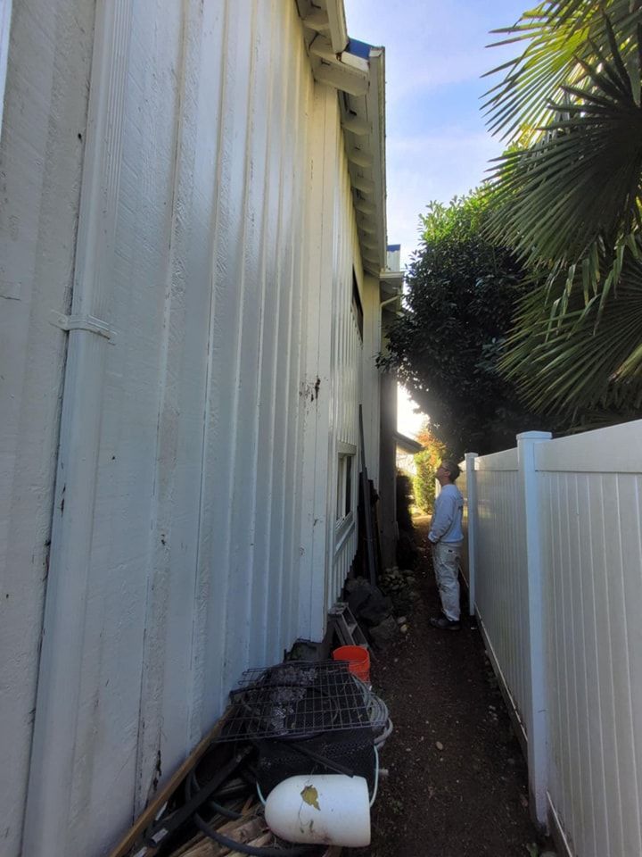 A Paint Right Painting team member inspects the exterior of a home in preparation to paint. 