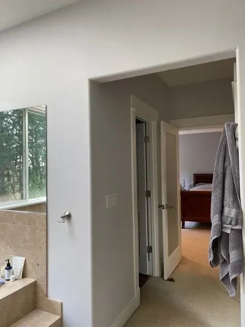 A master bathroom matches the adjoining bedroom with it's fresh, light-gray interior.