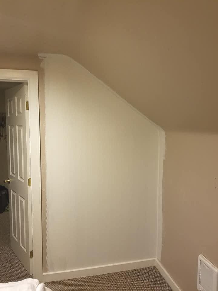 Freshly drywalled wall with clean white trim in a finished interior space.