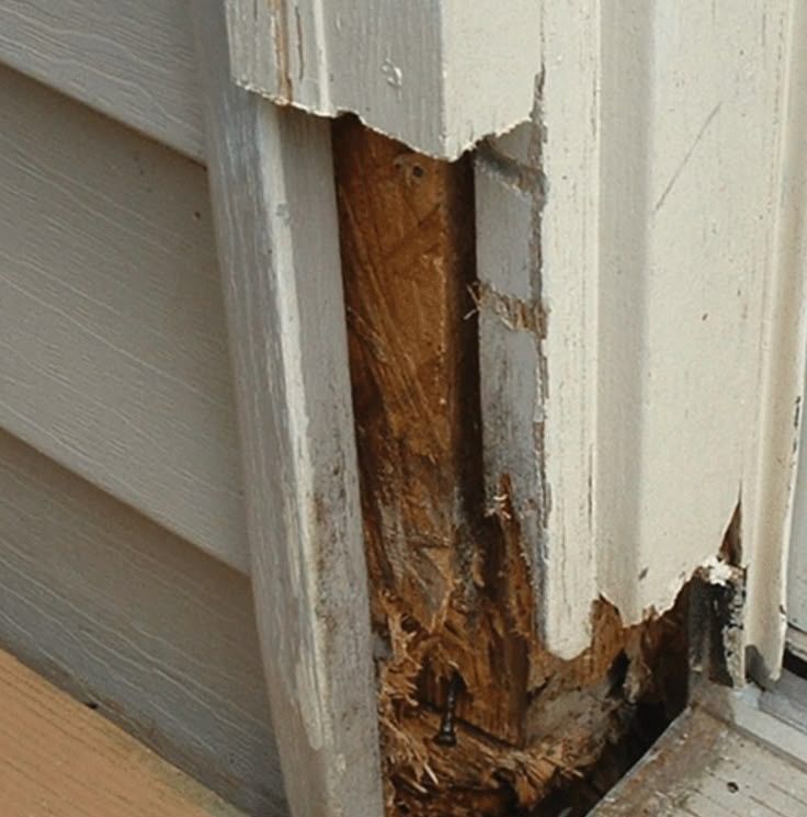 The trim and exterior siding of a house is crumbling due to wood rot. 