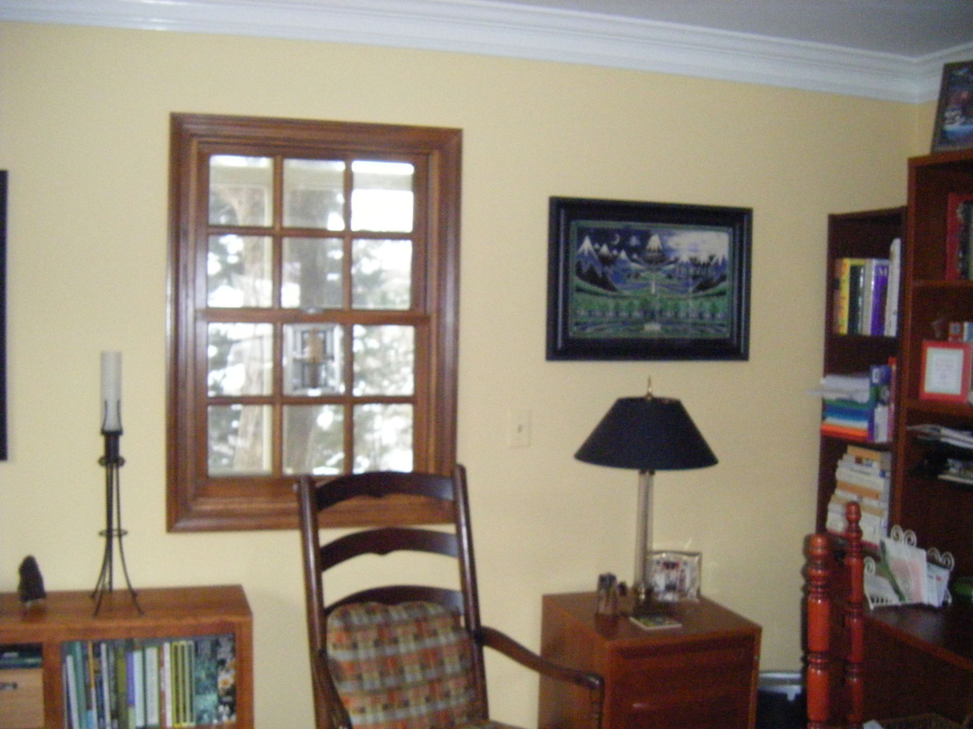 Soft yellow walls with white crown molding create a bright and cozy bedroom atmosphere. 