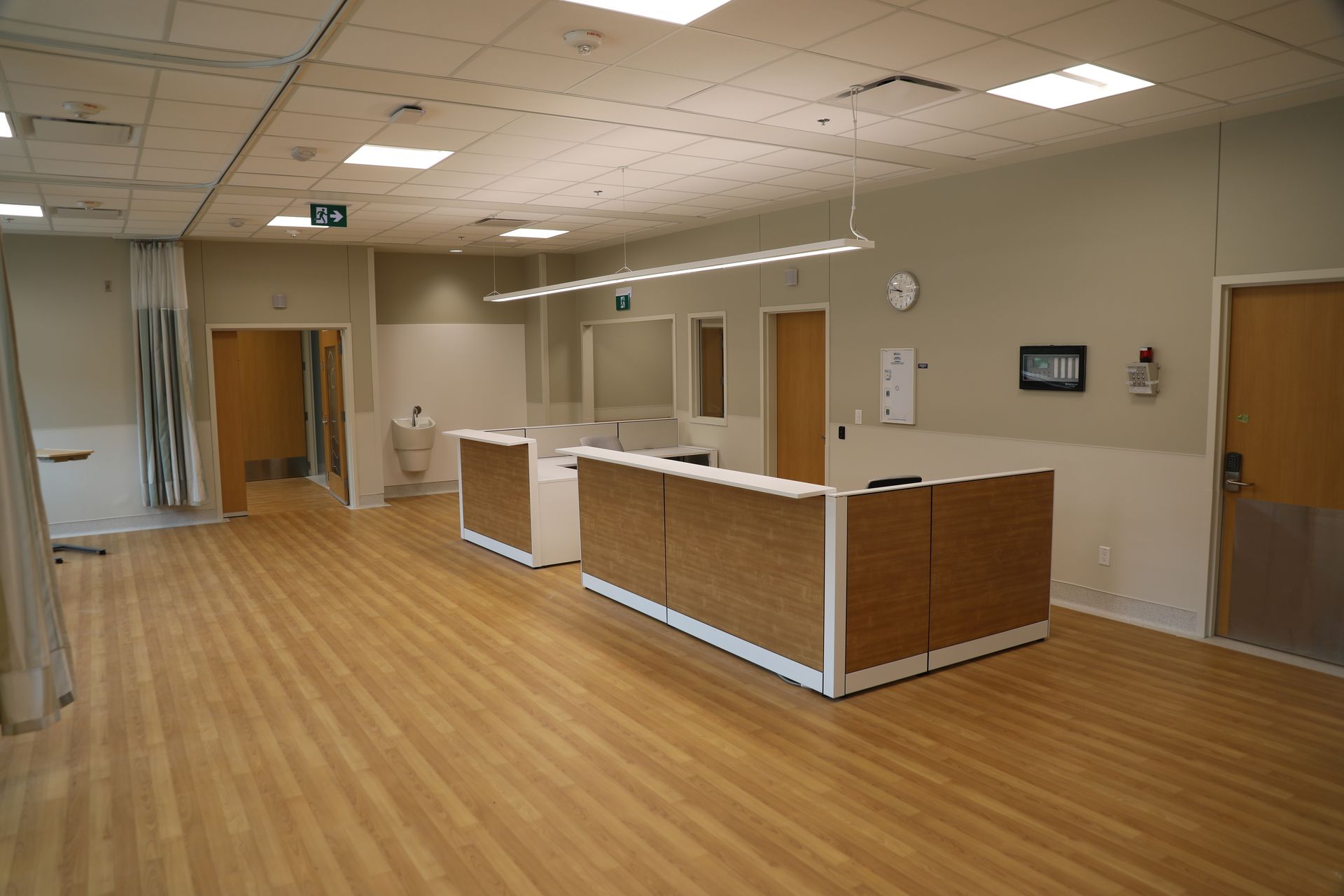 A large room with wooden floors and a reception desk.