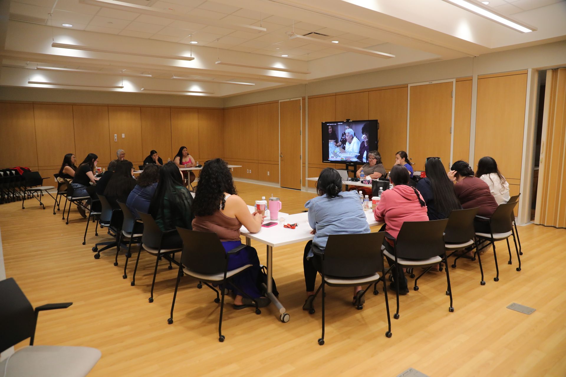 A group of people are sitting around a table in a room.