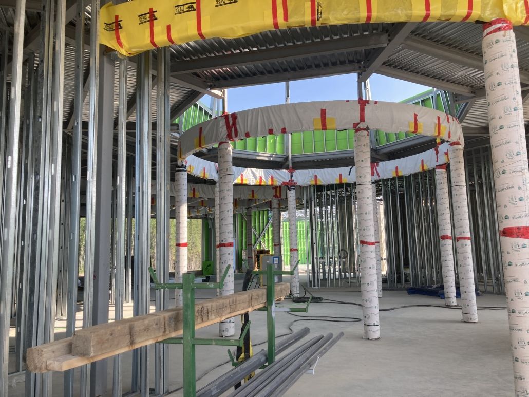 The inside of a building under construction with a yellow tarp on the ceiling.