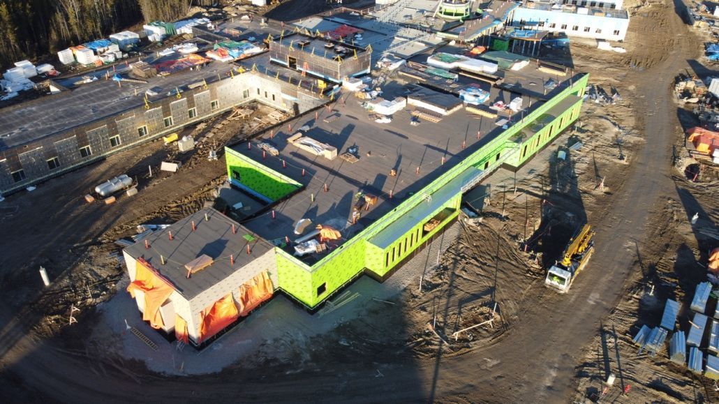 An aerial view of a large building under construction in a city.