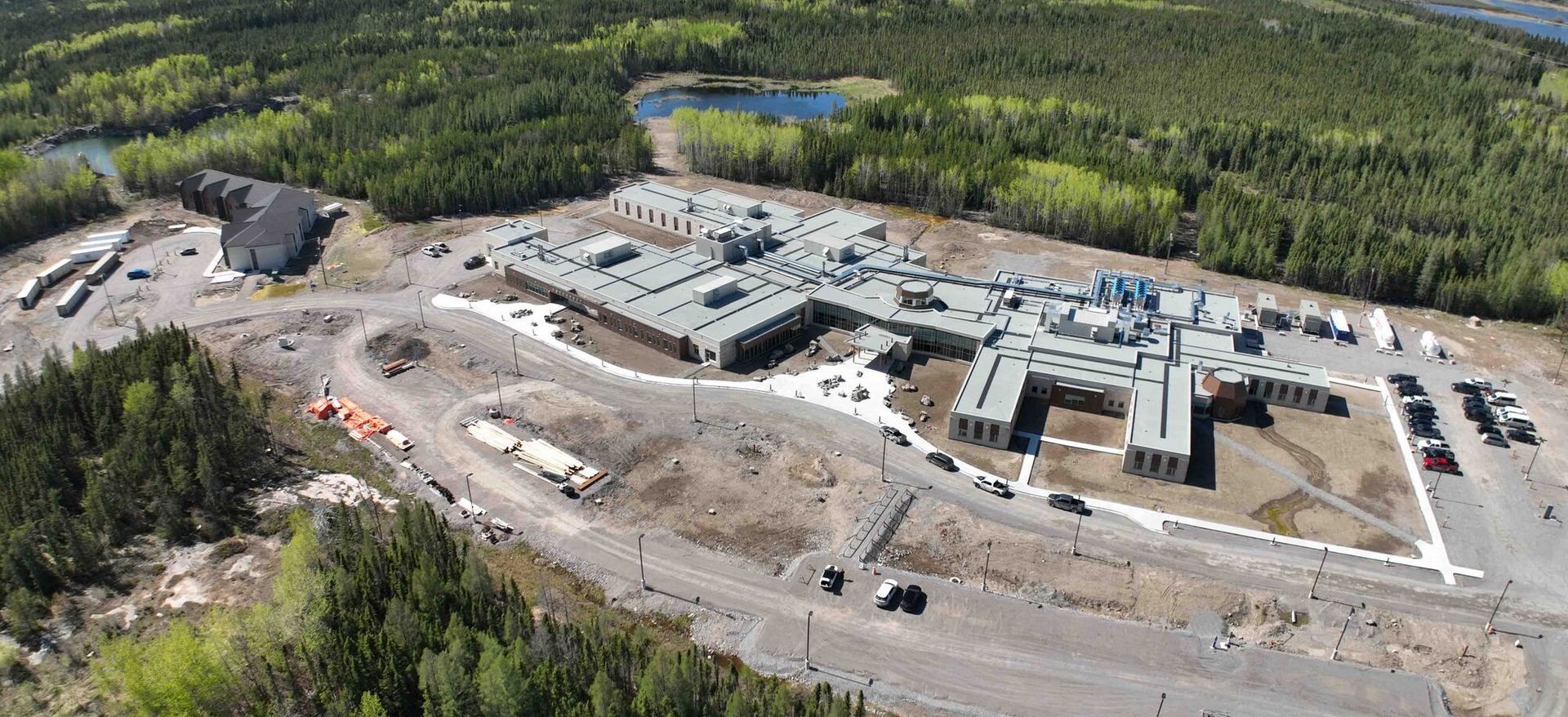 An aerial view of a large building in the middle of a forest.