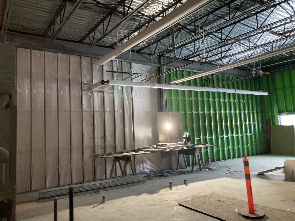 The inside of a building under construction with green walls.