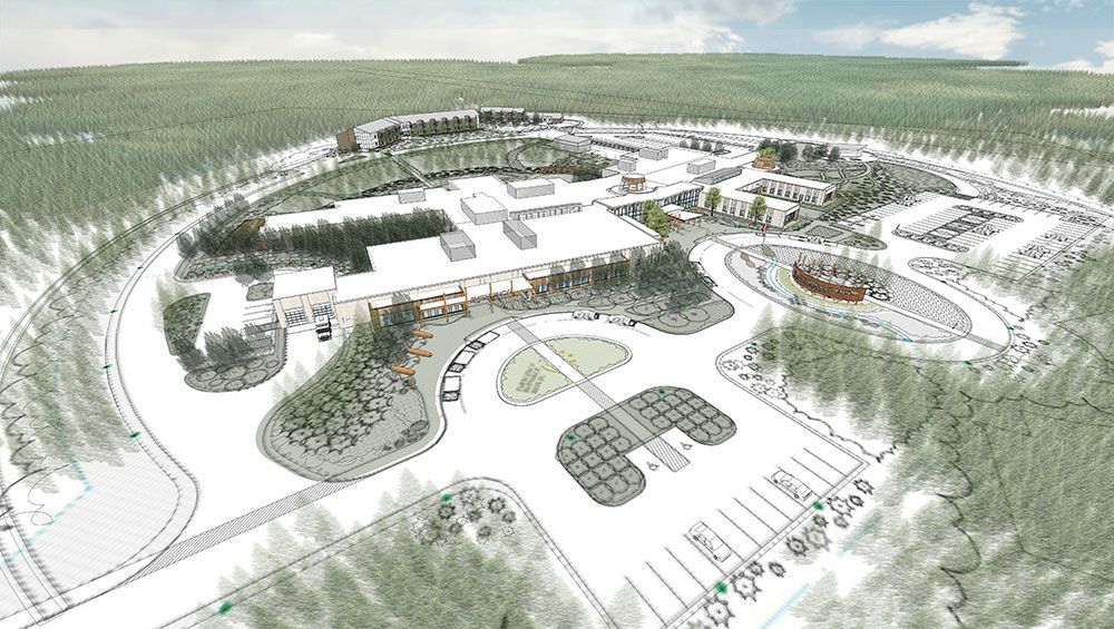 An aerial view of a large building in the middle of a forest.