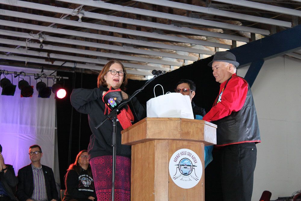 A woman is standing at a podium talking into a microphone.